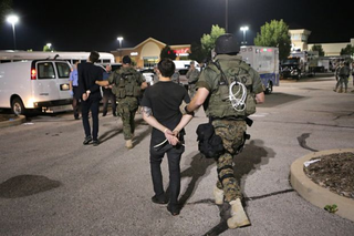 Members of the St. Louis County Police tactical team take a pair of journalists into custody on Aug. 19, 2014. Journalists Lukas Hermsmeier, left, a reporter for Bild, a German newspaper, and Ryan Devereaux, a reporter for theintercept.com, were in the area when police arrived. (David Carson/St. Louis Post-Dispatch)
